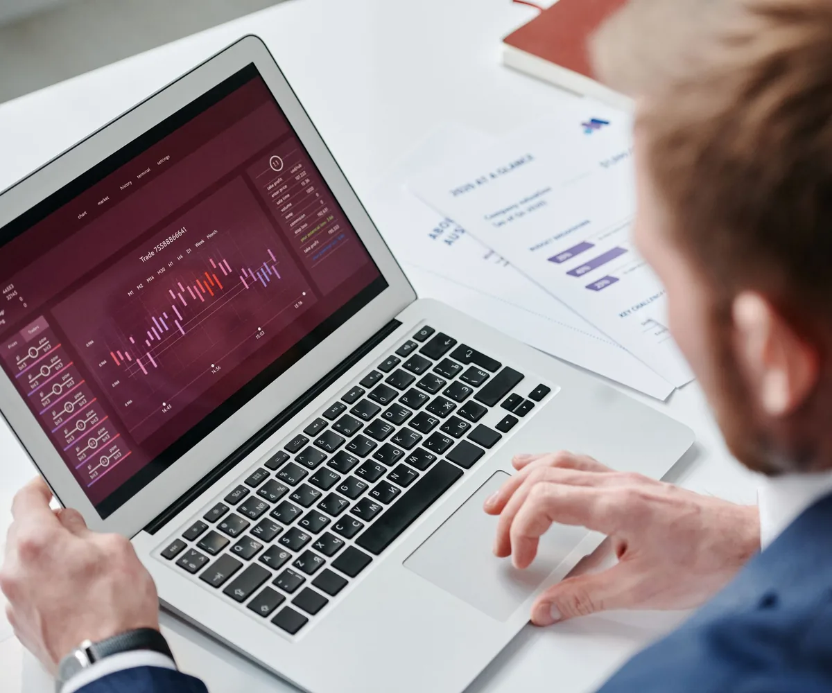 Mann im Anzug prüft ein Analyse-Dashboard auf dem Laptop